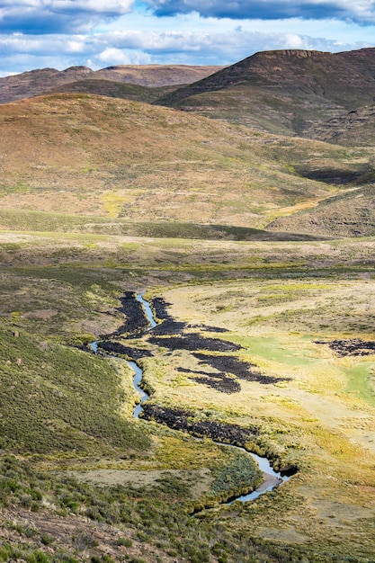 Viaje para Lesoto Um rio serpenteia no fundo de um vale no meio das montanhas