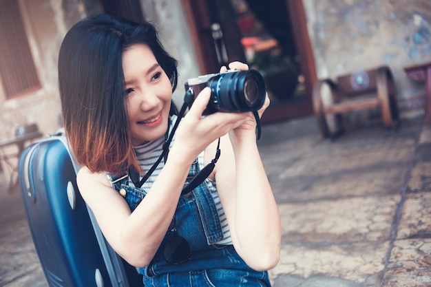 viaje de pelo corto hermosa mujer asiática con vestido casual y cámara con felicidad