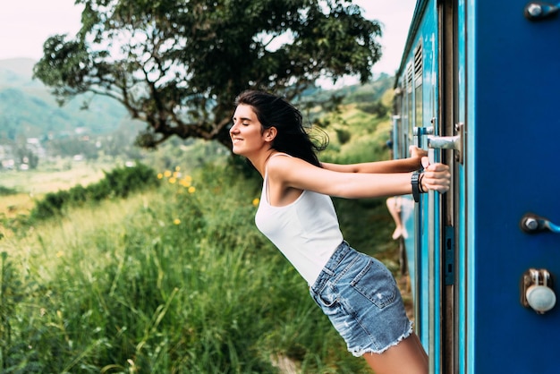 Viaje en tren. La niña viaja en tren a lugares hermosos. Hermosa chica viajando en tren entre montañas. Viajar el mundo. Trenes Sri Lanka. Transporte ferroviario. Ferrocarril. Transporte Asia