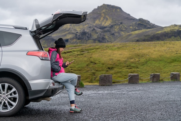 Viaje turístico de la mujer en coche SUV en Islandia.