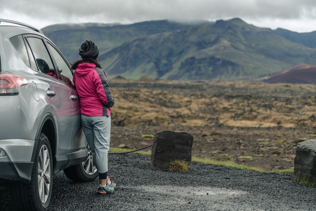 Viaje turístico de la mujer en coche SUV en Islandia.