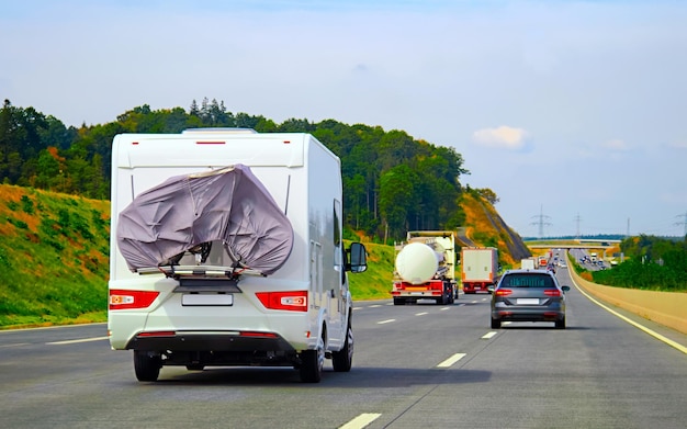 Viaje de vacaciones con Caravan Car con bicicleta en carretera, Suiza. Camper y Summer conducen por la autopista. Viaje de vacaciones en autocaravana rv para recreación. Paseo en movimiento de minivan de casa rodante en la naturaleza. Paisaje.