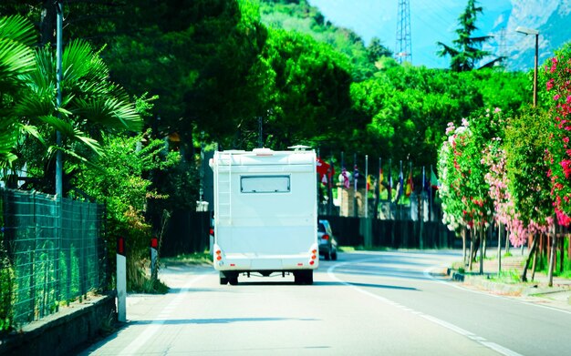 Foto viaje de vacaciones con caravan car en carretera en italia. camper y summer conducen por la autopista. viaje de vacaciones en autocaravana rv para recreación. paseo en movimiento en minivan de autocaravana. paisaje con vehículo mini van.