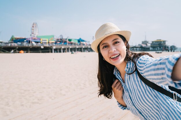 una viajera tomando selfie con una atractiva sonrisa en la cara