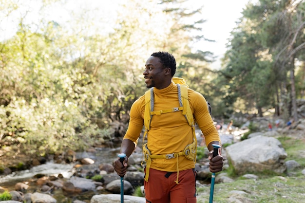 Un viajero afroamericano camina por el bosque con una mochila.