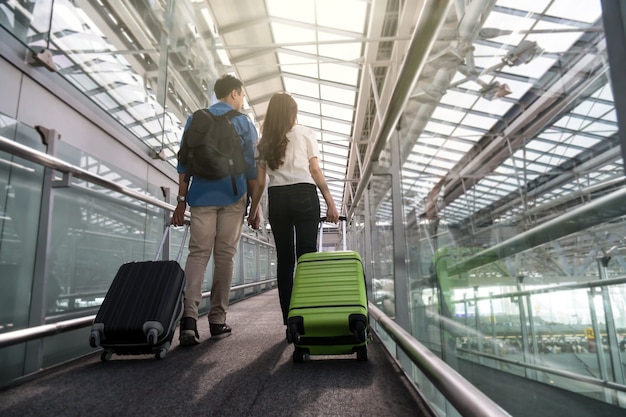 Viajero asiático de la pareja con las maletas en el aeropuerto. Amante de viajes y transporte con tecnología