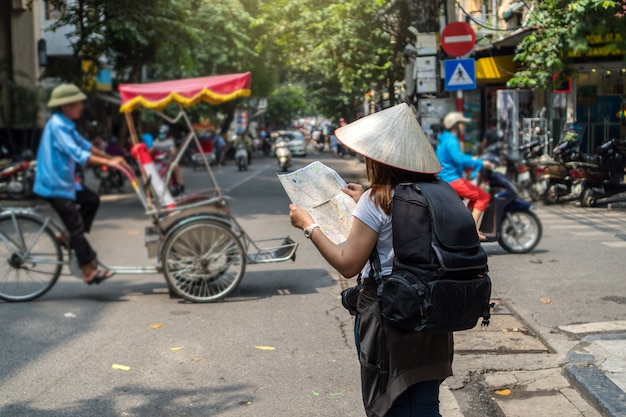 Viajero asiático sosteniendo y mirando el mapa para viajar a la ciudad de hanoi