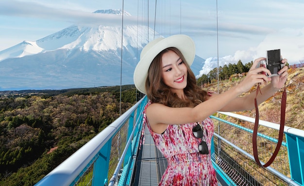 Viajero asiático toma una foto en el puente colgante con vistas a la montaña Fujiyama de fondo Tokio