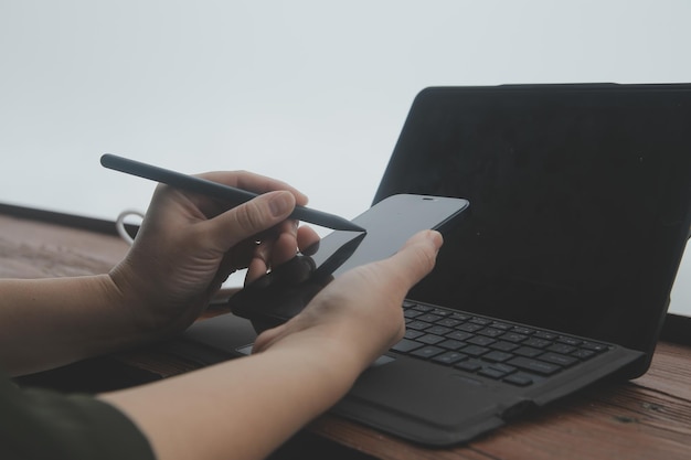 Viajero autónomo joven con sombrero en cualquier lugar trabajando en línea usando una computadora portátil y disfrutando de la vista de las montañas