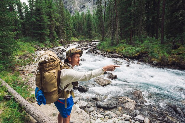 Viajero en camino a lo largo del río de montaña.