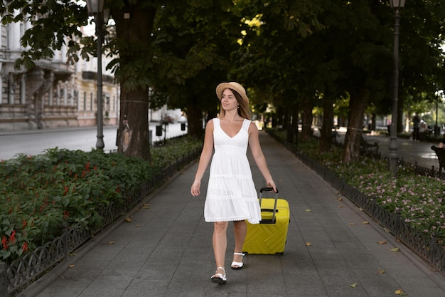 Viajero chica camina por la calle en la ciudad de Europa con una maleta en sus manos