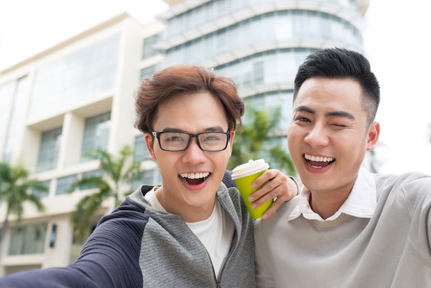 Viajero de dos hombres vietnamitas tomando selfie en ciudad extranjera