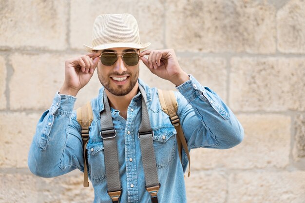 Viajero con estilo hombre barbudo con sombrero posando mirando a la cámara concepto de viaje y pasión por los viajes
