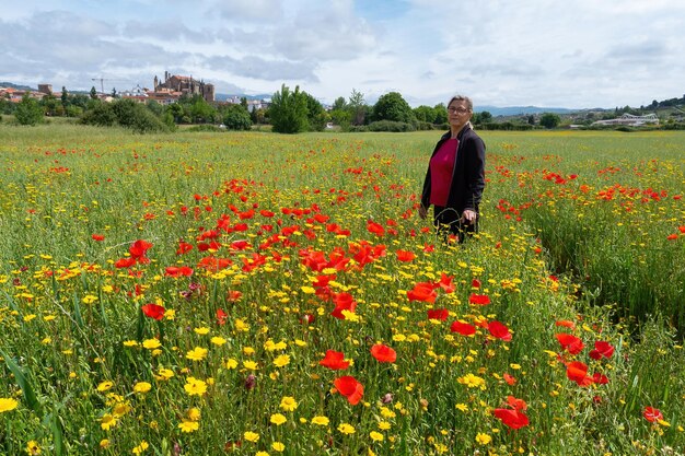 Viajero feliz mujer madura con ramo de flores rojas de amapola