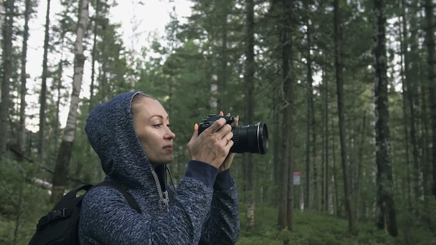 Viajero fotografiando vistas panorámicas en el bosque Una mujer caucásica