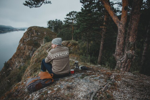 Viajero hipster con mochila vintage en la naturaleza