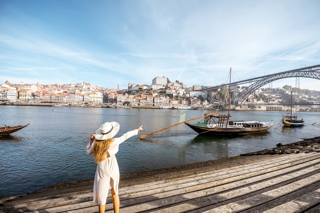 Viajero joven disfrutando de la hermosa vista del paisaje urbano del río Duero y barcos tradicionales portugueses durante la luz de la mañana en Oporto, Portugal