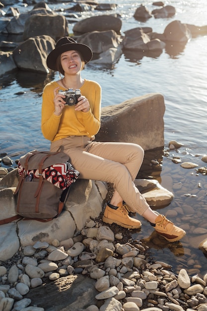 Viajero joven está tomando fotografías de la naturaleza en cámara retro