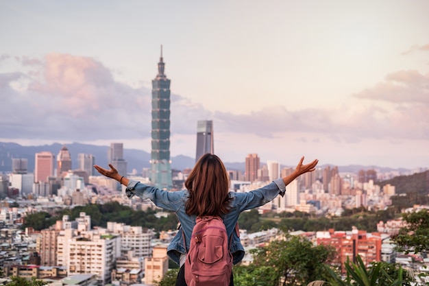 Foto viajero joven mirando hermoso paisaje al atardecer en taipei