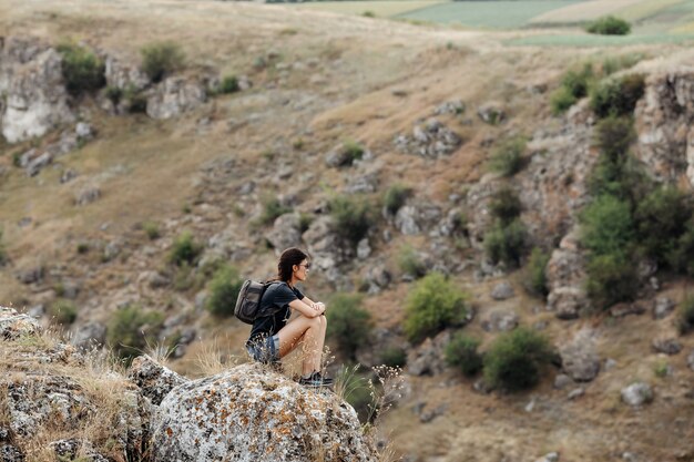 Viajero joven, de pie en la cima de una montaña