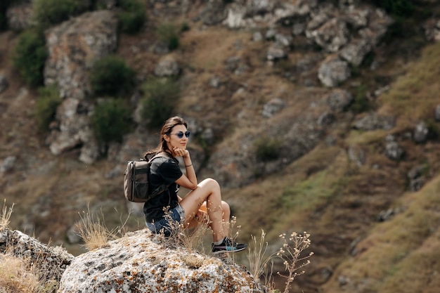 Viajero joven, de pie en la cima de una montaña