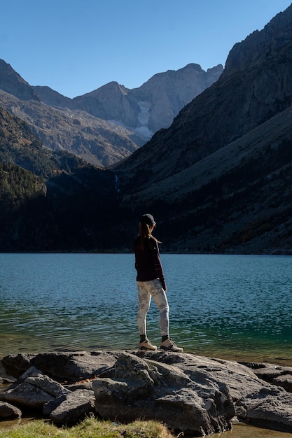 Viajero joven de pie sobre las rocas en la orilla del lago de Gaube en los Pirineos franceses