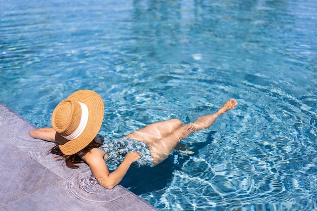 Viajero joven relajarse y disfrutar de una piscina tropical resort