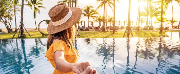 Foto viajero joven tomando una hermosa puesta de sol en la playa tropical resort