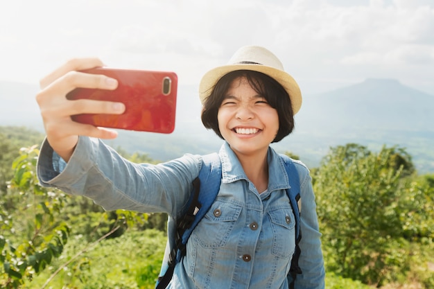 Viajero joven tomando selfie con vista a la montaña