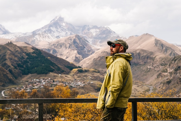 Viajero masculino activo con gafas de sol disfruta de la naturaleza y las aventuras de la montaña