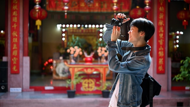 Un viajero masculino disfruta de su viaje en solitario en Tailandia y toma fotos en un templo chino