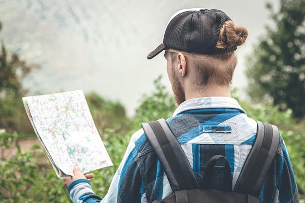 Viajero masculino mirando el mapa concepto de senderismo