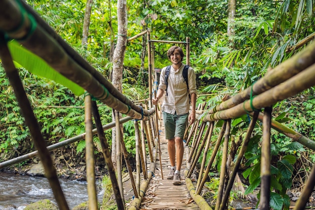 Viajero masculino en el puente colgante en Bali