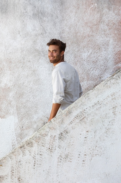 Foto viajero masculino sonriente en retrato de camisa blanca