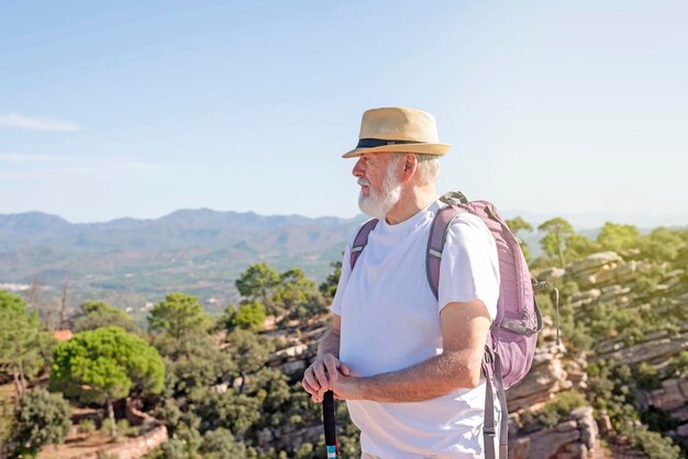 Viajero mayor con mochila de senderismo en las montañas Concepto de estilo de vida activo en la jubilación