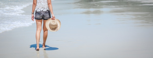 Viajero mujer asiática caminando en la playa