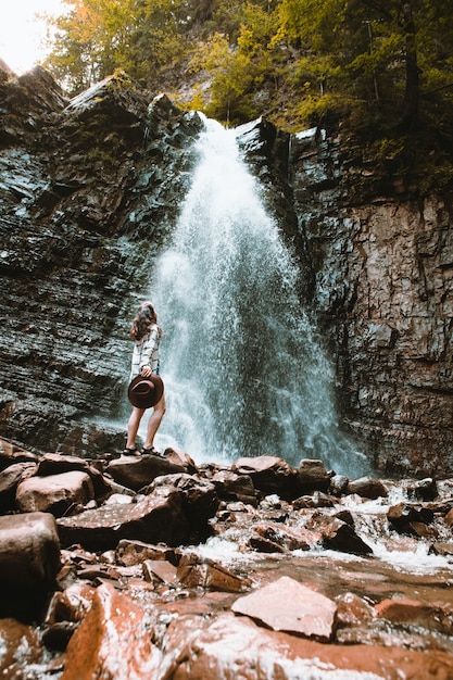 Viajero mujer disfrutando de la vista del espacio de copia de cascada