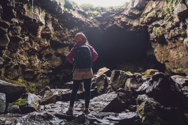 Viajero mujer explorar túnel de lava en islandia.