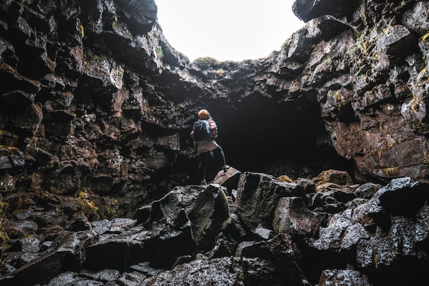 Viajero mujer explorar túnel de lava en Islandia.