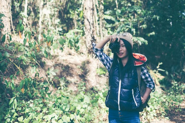 Viajero mujer joven con mochila en un bosque. Senderismo en verano.