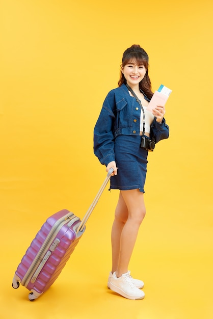 Viajero mujer con maleta sobre fondo de color