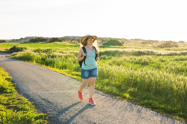 Viajero mujer mirando puesta de sol en campo verde