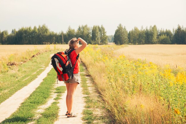 Viajero de mujer con mochila de senderismo en las montañas con un hermoso paisaje de verano