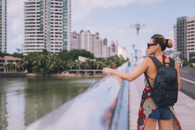 Viajero mujer mochilero rubia caminando en el centro de la ciudad asiática con rascacielos. Viaje aventura naturaleza en China, destino turístico hermoso Asia, vacaciones de verano viaje viaje concepto de viaje