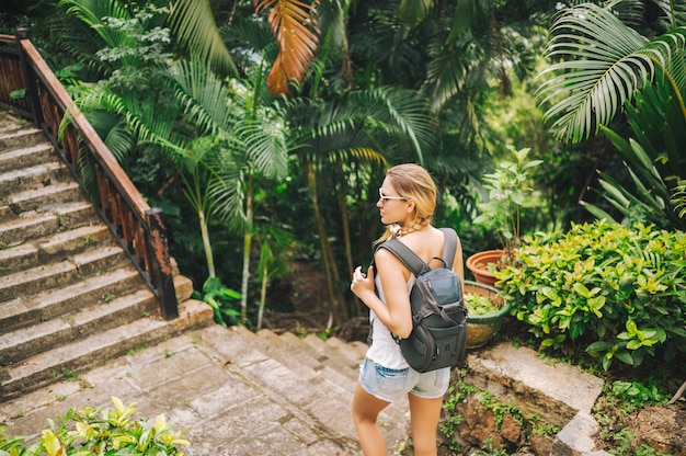 Viajero mujer mochilero rubia caminando y descubriendo el parque tropical de la jungla, viaje naturaleza de aventura en China, destino turístico hermoso Asia, concepto de viaje de vacaciones de verano vacaciones viaje