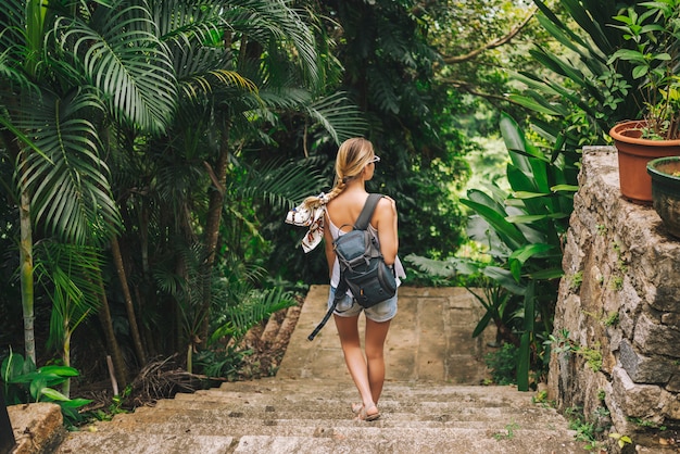 Viajero mujer mochilero rubia caminando y descubriendo el parque tropical de la jungla, viaje naturaleza de aventura en China, destino turístico hermoso Asia, concepto de viaje de vacaciones de verano vacaciones viaje