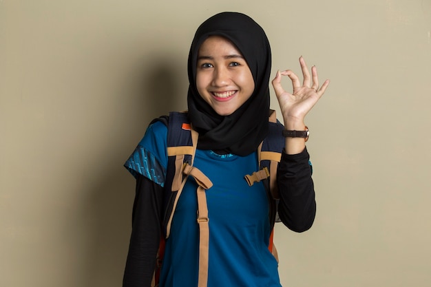 Viajero de mujer musulmana asiática con hijab con gesto de signo ok