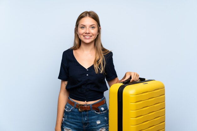 Foto viajero mujer rubia con maleta sonriendo mucho