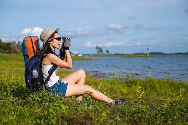 Viajero mujer sentada cerca del lago en la montaña