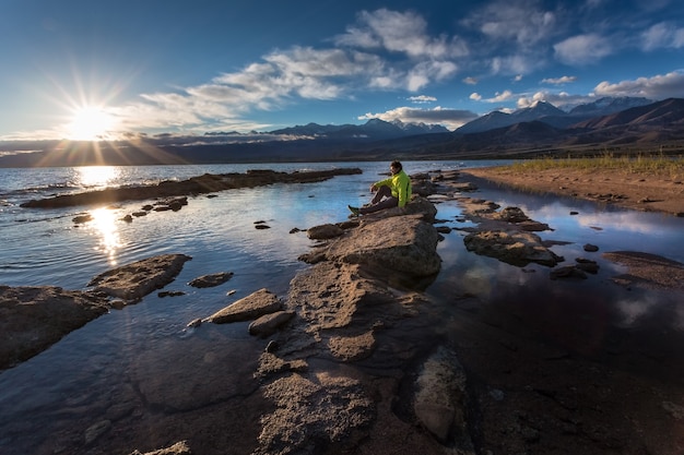 Viajero en la orilla de un lago de montaña